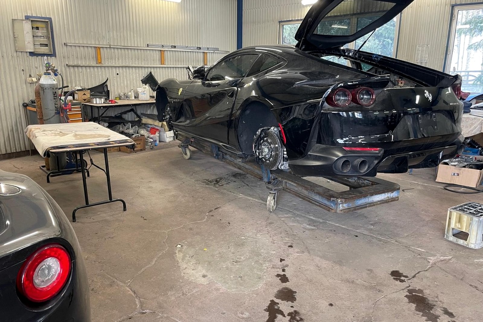 Ferrari 812 Superfast na wózku warsztatowym z częściowo zdemontowanym przodem.