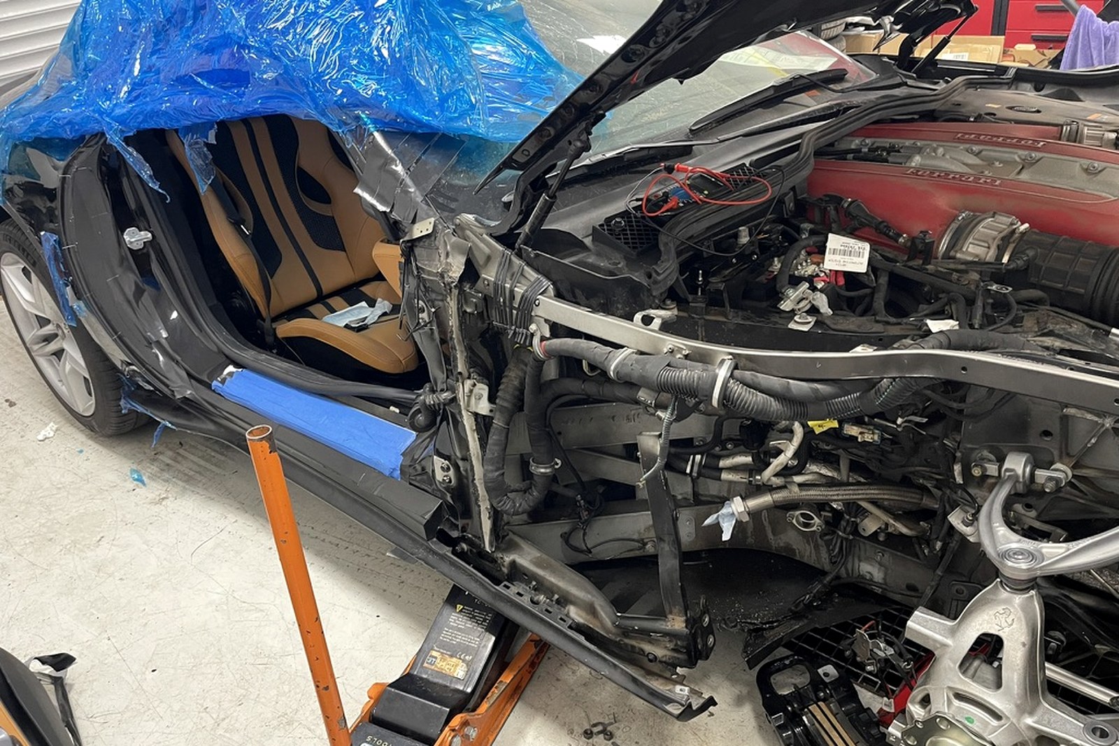 Rozebrany przód Ferrari 812 Superfast z odsłoniętą komorą silnika V12 i strukturą przednią.