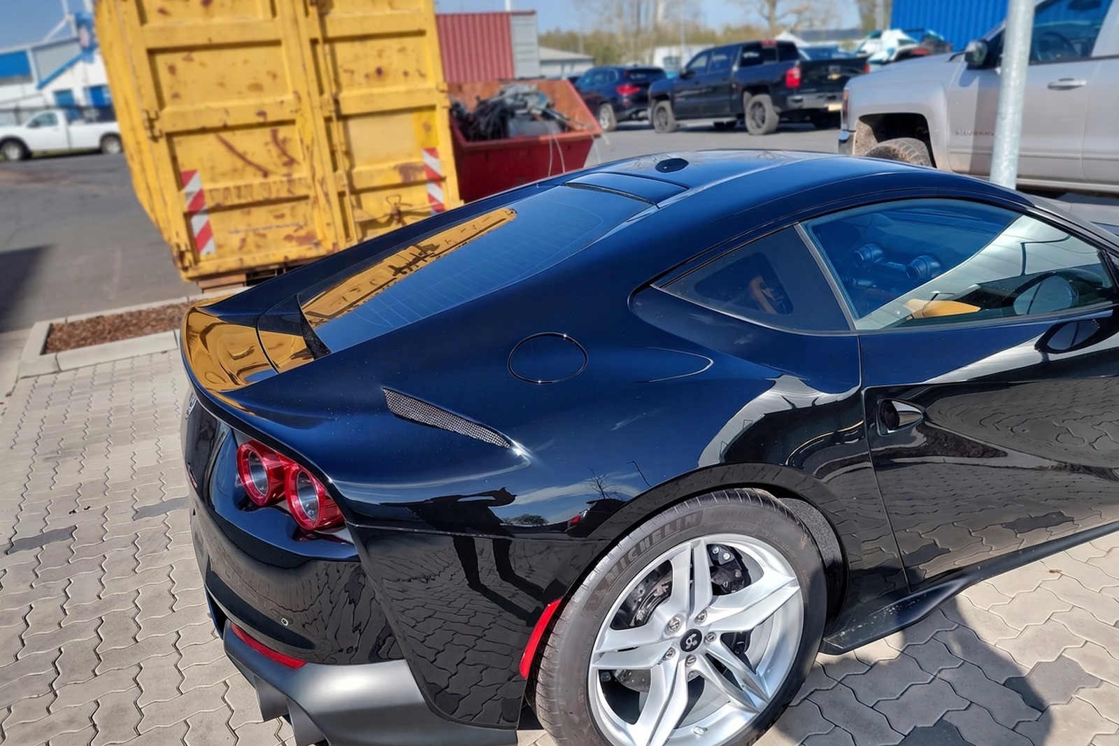 Detal tylnego błotnika odbudowanego Ferrari 812 Superfast — nienaganny czarny lakier i spasowanie elementów.