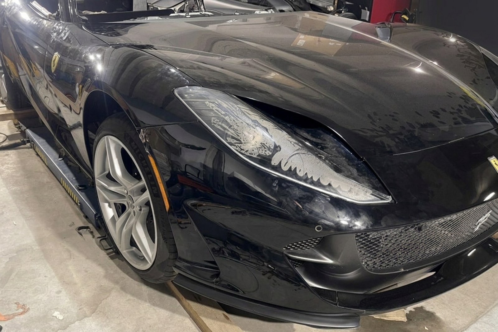 Złożony przód Ferrari 812 Superfast w warsztacie, z regulacją spasowania zderzaka, reflektora i błotnika.