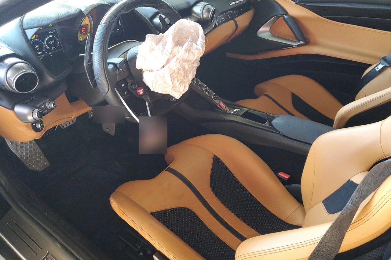 Ferrari 812 Superfast w stanie przyjęcia — wnętrze po zdarzeniu, z odpaloną poduszką powietrzną.